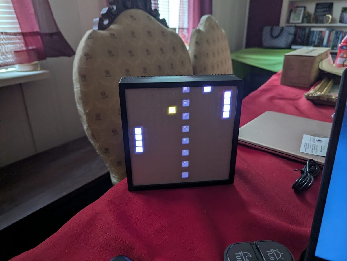 Pong on the 16x16 LED matrix, showing two paddles, a center net, and the ball
