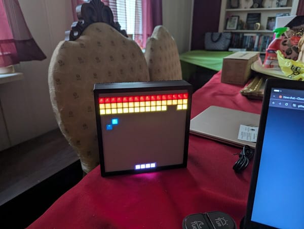 ESP32-powered 16x16 WS2812B LED matrix in a black frame playing Breakout, with a Stadia controller in front
